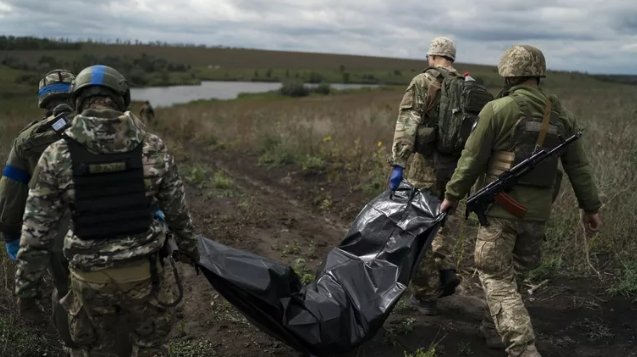 Фото: AP Photo / Leo Correa Украинские военнослужащие несут тело погибшего. Архивное фото